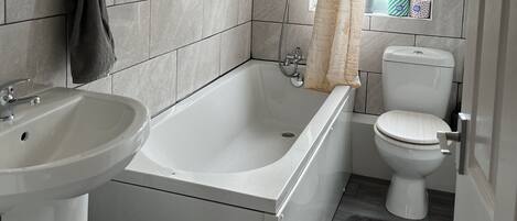 Un baño moderno con bañera, inodoro y lavabo.