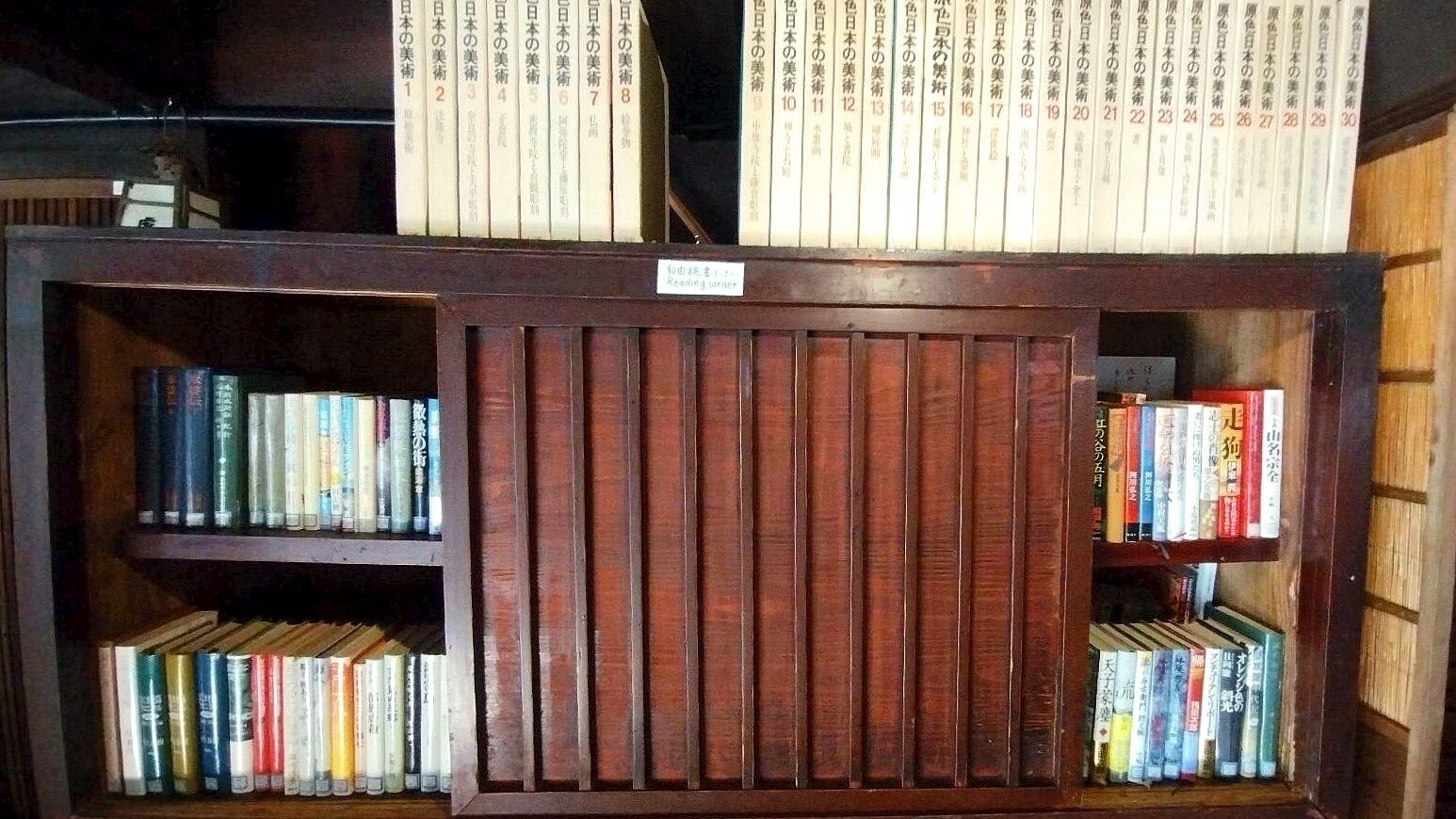 Une bibliothèque avec des étagères de chaque côté et une section centrale dotée d’une porte fermée.