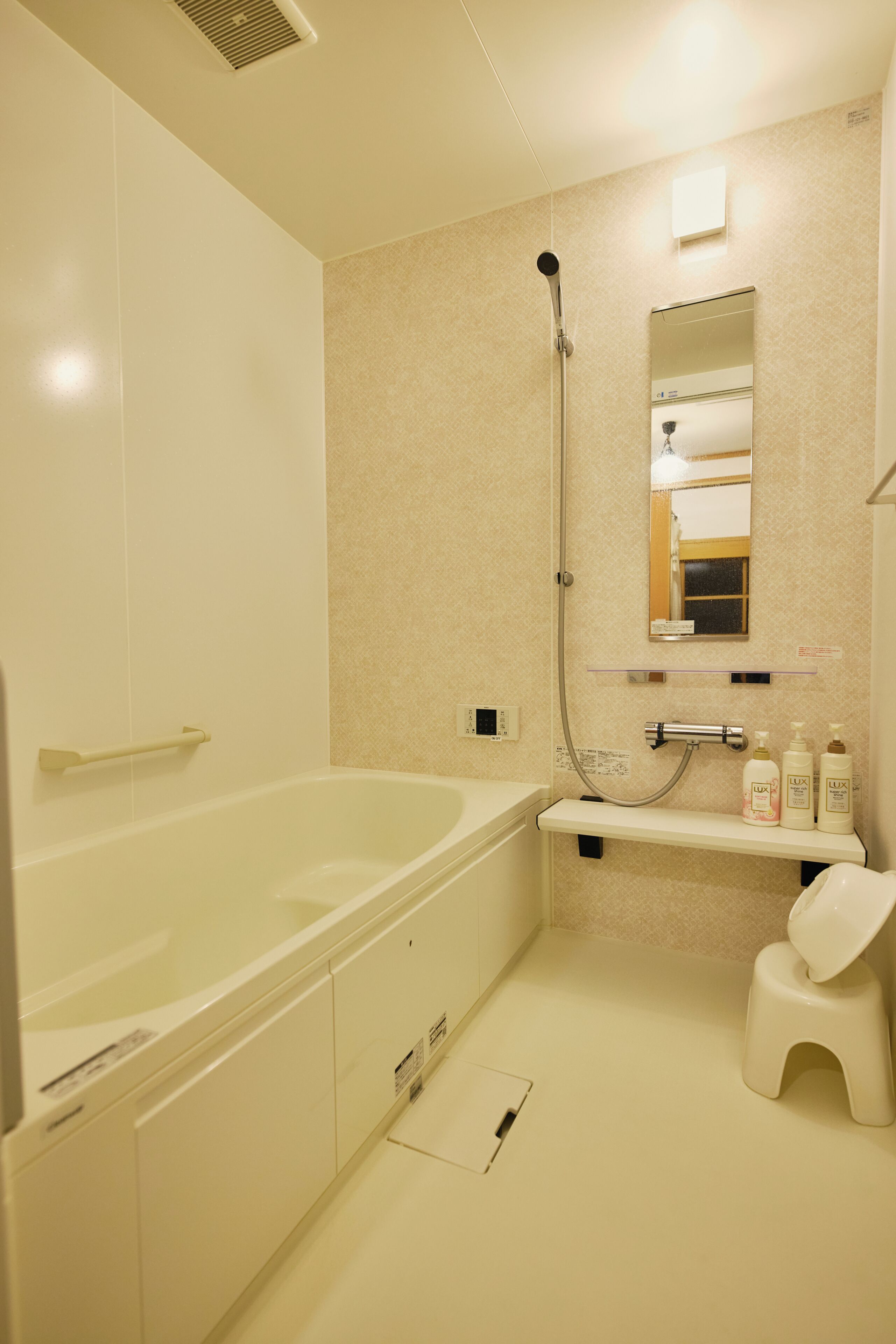 A bathroom with a bathtub, a shower, a toilet, and a mirror.