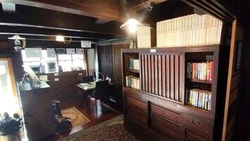 Una habitación con una estantería de madera, un escritorio con una silla y una pequeña alfombra en el suelo.