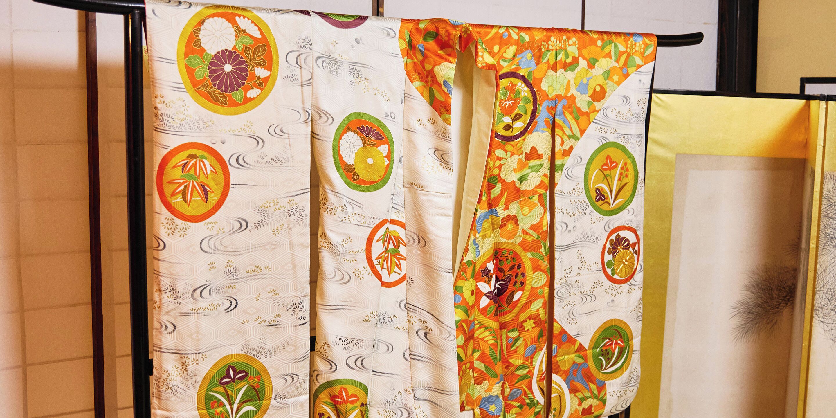 A set of curtains with floral patterns and a geometric design, hanging on a black metal rod.