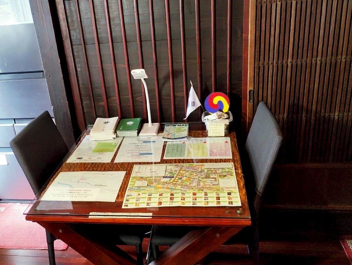 A wooden table with various documents, a map, and a small flag.