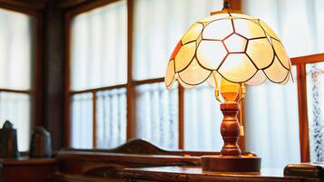 Una lámpara con diseño de balón de fútbol sobre una mesa de madera en una habitación con ventanas amplias.