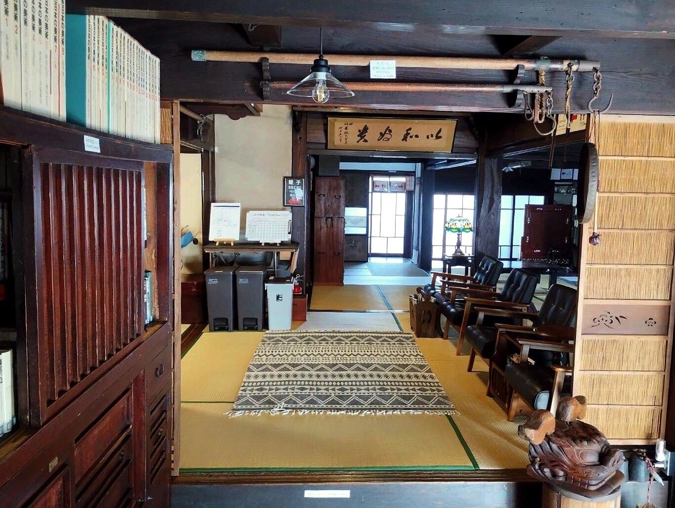 A traditional Japanese room with tatami mats, a shoji screen, and a wooden desk with a computer.