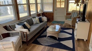Un salon confortable avec un canapé, des fauteuils, une table basse et un téléviseur.