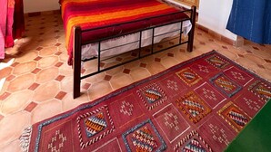 Quarto com cama, guarda-roupa de madeira e janela com cortina.