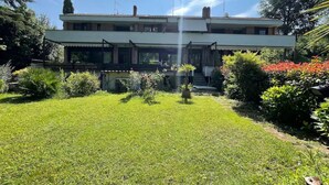 Une maison à deux étages avec une pelouse et un jardin bien entretenus.
