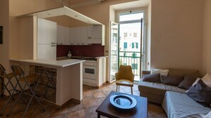 A compact living space with a kitchenette, a dining area, and a sofa. - La Dolce Vita - IRIDE's Nest (Roma)