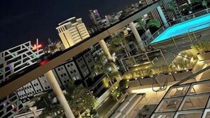 A rooftop terrace with a pool, potted plants, and outdoor seating. - Best Apartment in Downtown (Santo Domingo)
