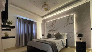 A modern bedroom with a large bed, a marble-patterned wall, and a ceiling light fixture. - Best Apartment in Downtown (Santo Domingo)