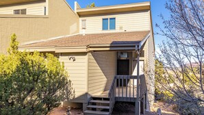 A two-story building with a front entrance, a small porch, and a visible door. - Bear Paw (Flagstaff)