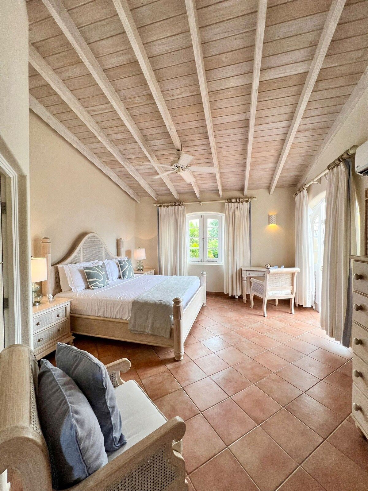 Une chambre à coucher avec un lit, des tables de chevet, un bureau et une chaise.