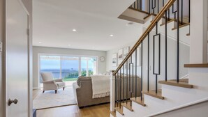 Un intérieur moderne avec un escalier, un canapé et une vue sur l’extérieur.