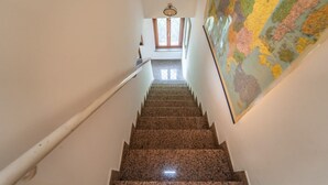 Eine Treppe mit Handlauf, eine Wand mit einer Karte und ein Fenster im Obergeschoss.