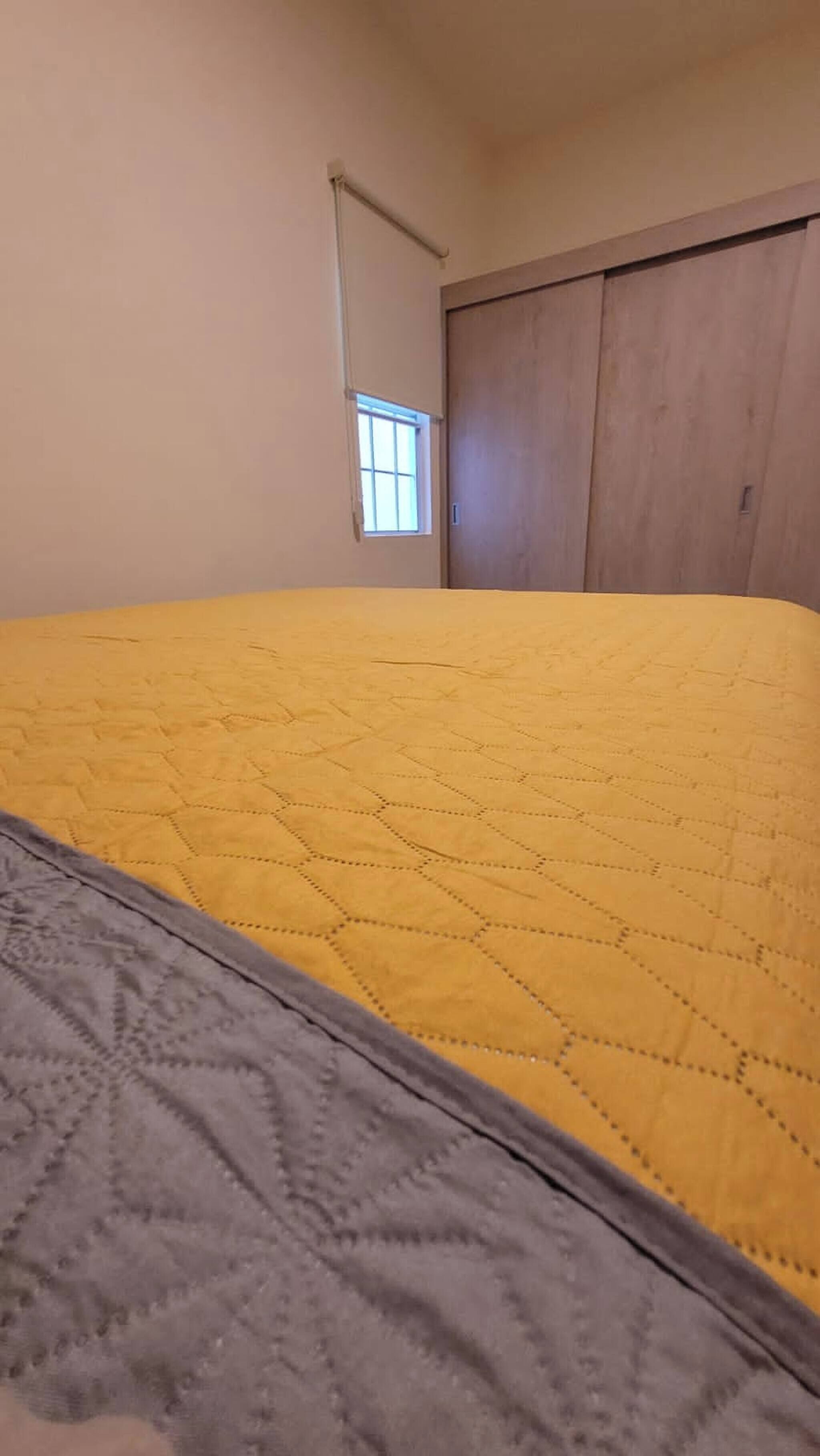 A room with a bed, a window, and a wardrobe.