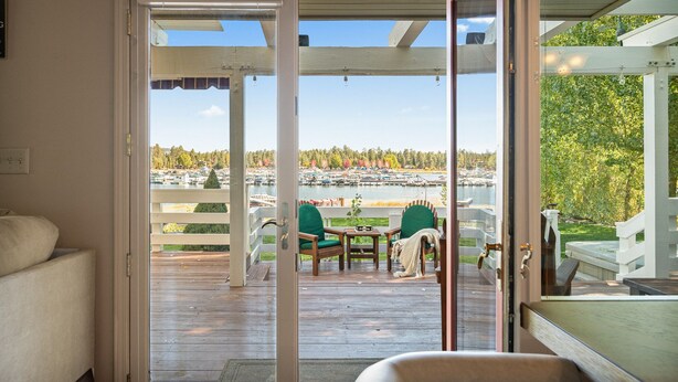 A wooden deck with a view of a lake and boats. - Lakefront, Spa, Pool Table, King Beds, Fireplace, Deck, Grill, Private Dock (Big Bear Lake)
