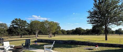 An outdoor patio area with a fire pit, seating, and a stone wall.