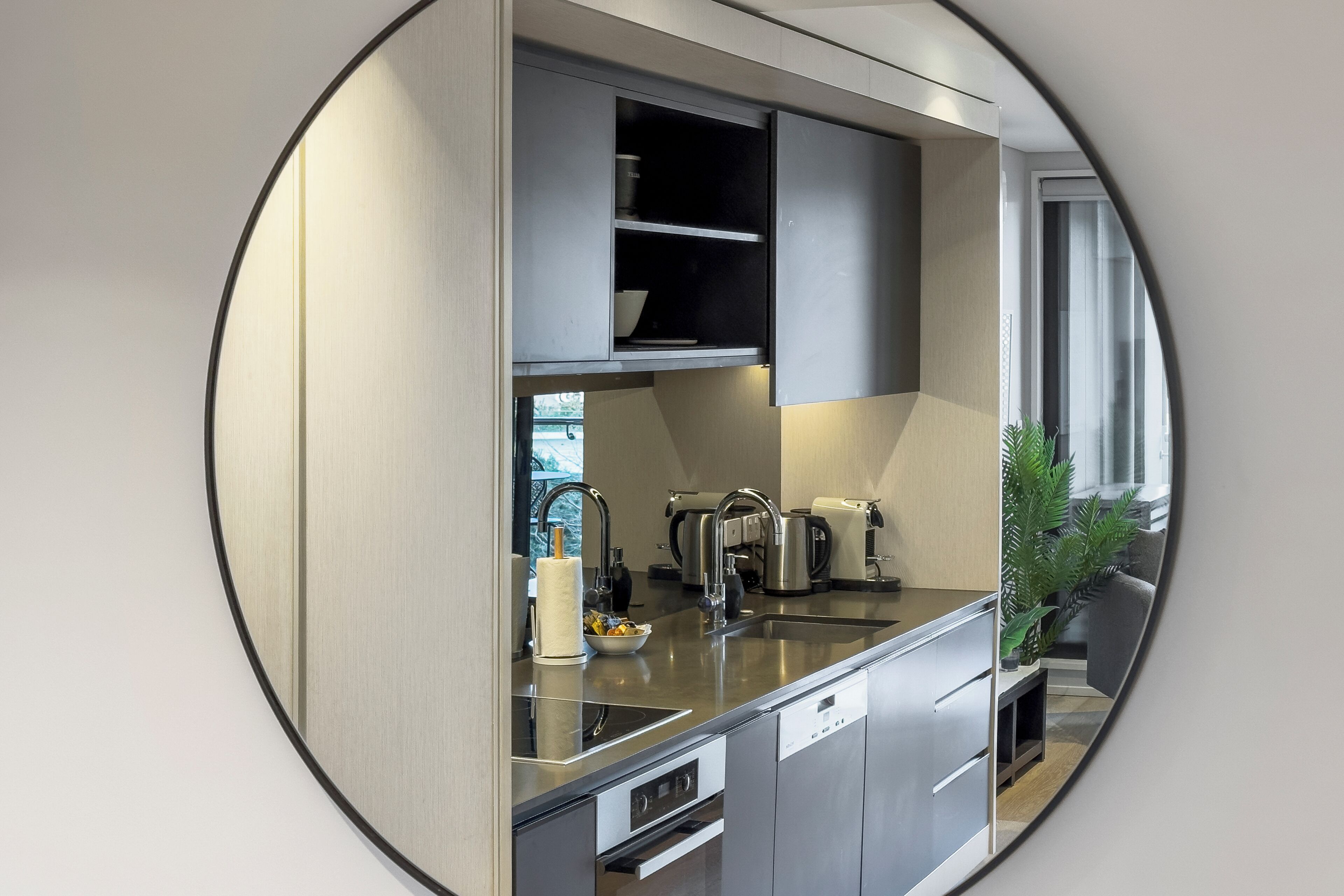 A modern kitchen with stainless steel appliances, a built-in oven, and a window providing natural light.