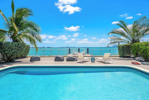 Una piscina con lettini prendisole e vista sull'oceano.
