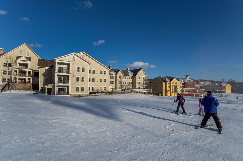 A ski resort with multi-story buildings and a snow-covered slope.