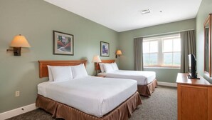 A hotel room with two beds, a desk, and a TV. - Okemo | 2BR + Exec Loft Condo w/ Washer & Dryer (Ludlow)