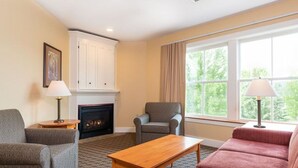 A living room with a fireplace, two armchairs, a sofa, and a coffee table.