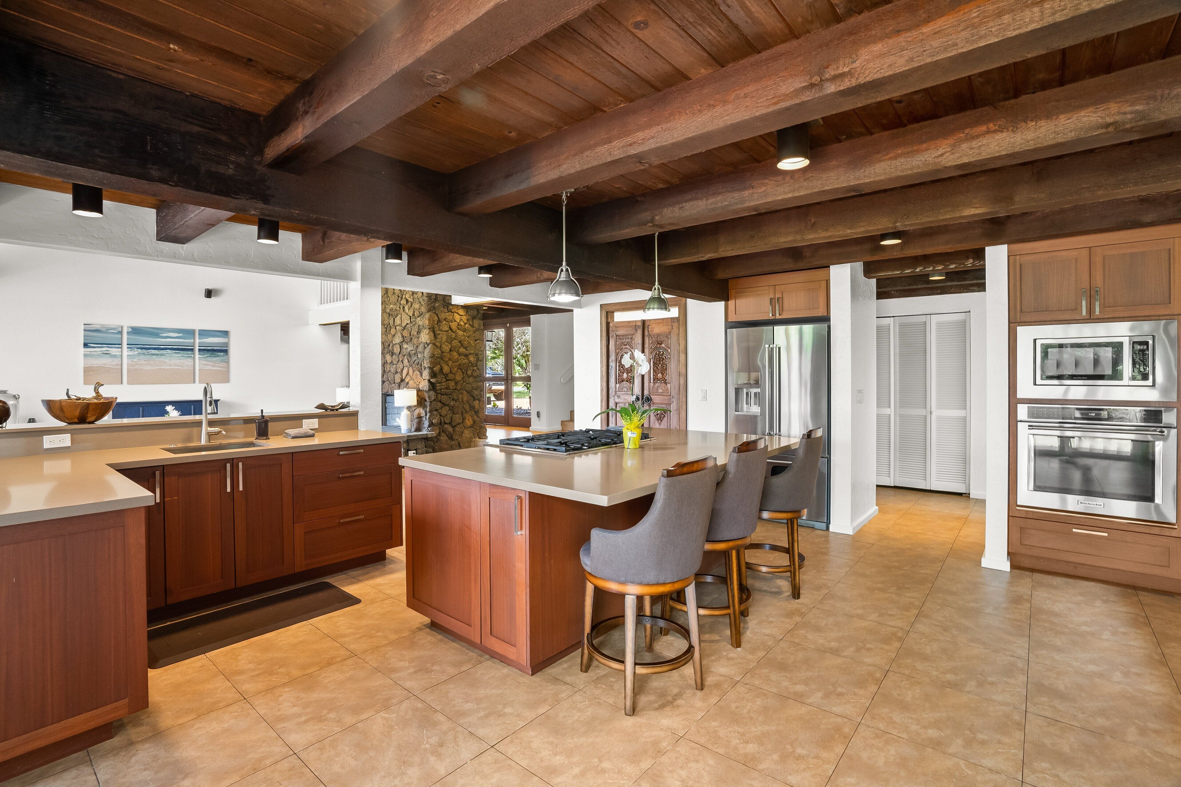 A spacious kitchen with a large island, wooden cabinets, and modern appliances.