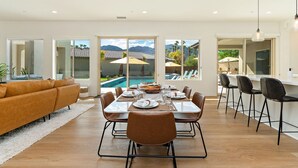 A spacious dining area with a view of a swimming pool and mountains. - Palmer Retreat: #260334 3 BR, Pool, Spa, Foosball! (La Quinta)