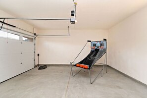 A basketball court with a backboard and hoop, a garage door, and a concrete floor. - Palmer Retreat: #260334 3 BR, Pool, Spa, Foosball! (La Quinta)