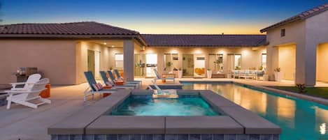 A swimming pool with lounge chairs and a patio area.
