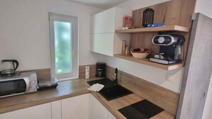 A compact kitchen with a microwave, coffee maker, and a small sink. - Studio detached with garden (Medulin)