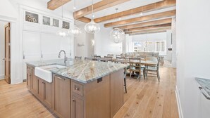 A spacious kitchen with a large island, wooden beams, and pendant lighting. - Gulf Views, Private Heated Pool, Steps to Beach, Rooftop | Kayaks, 6 Bikes (Inlet Beach)