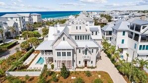 A coastal residential area with white houses, a swimming pool, and a view of the ocean. - Gulf Views, Private Heated Pool, Steps to Beach, Rooftop | Kayaks, 6 Bikes (Inlet Beach)