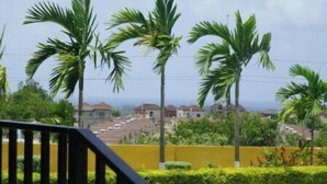 A pool area with a view of palm trees and houses in the background. - Private Retreat Getaway (Florence Hall Village)