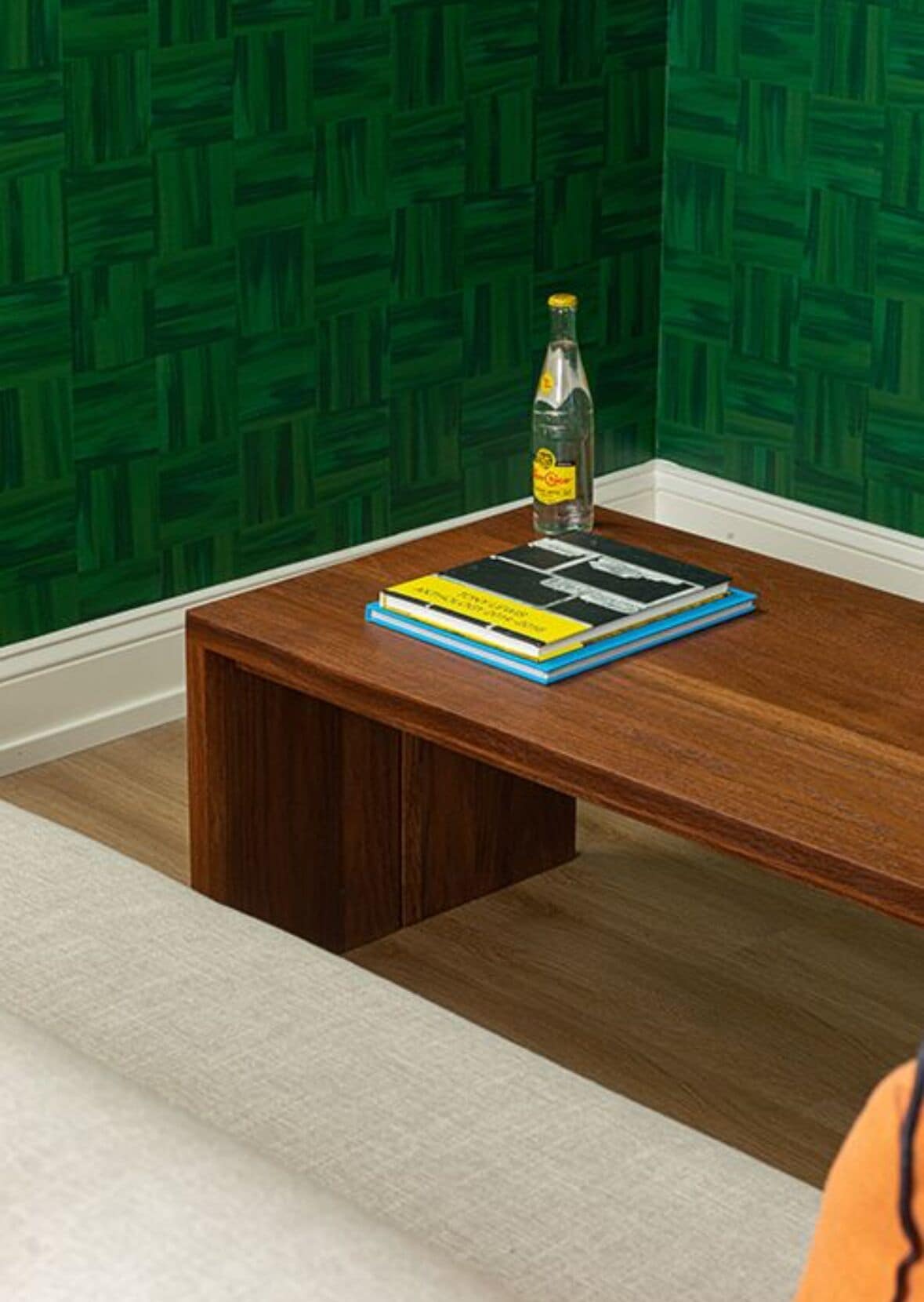 Ein Holztisch mit einer Flasche und Büchern.