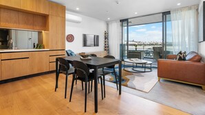 A modern living space with a kitchen, dining area, and seating area with a view.