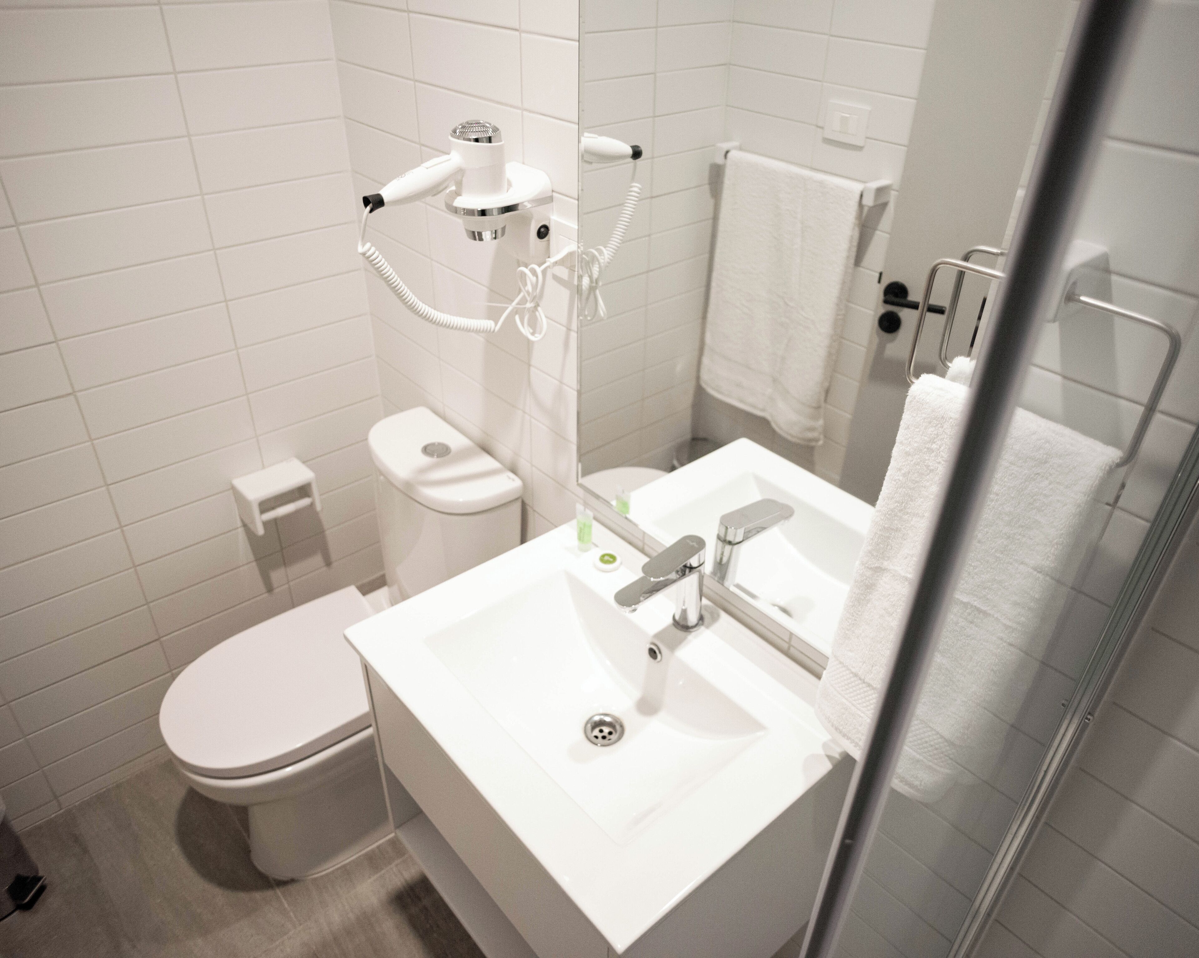 A modern bathroom with a toilet, sink, and shower.