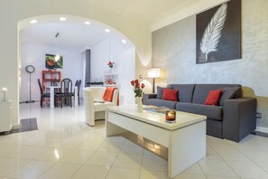 Un salon moderne avec un canapé gris, une table basse blanche et un coin repas à l’arrière-plan.