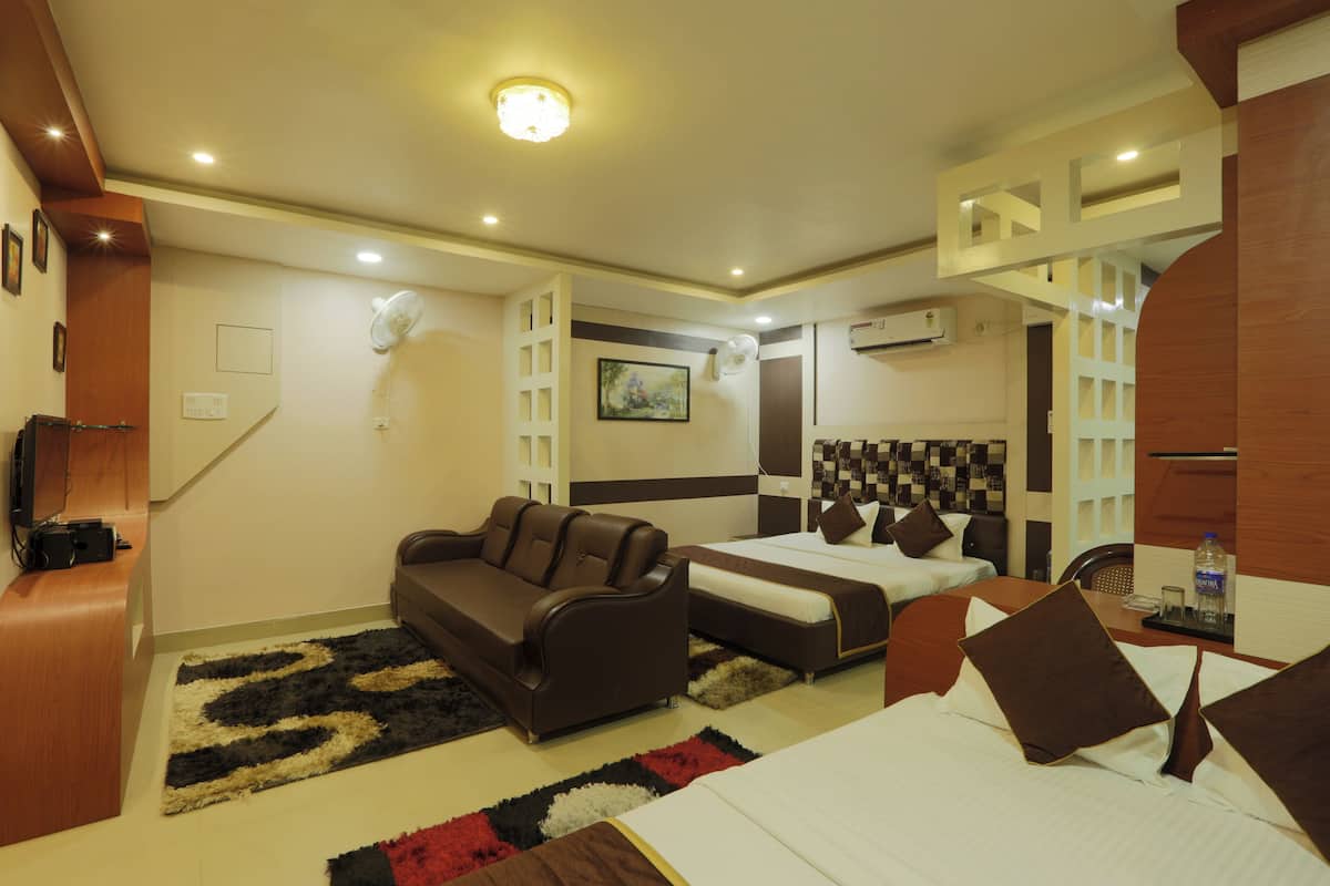 Une chambre d’hôtel avec un canapé, un lit, un bureau et une chaise.
