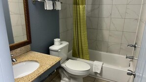 A bathroom with a sink, toilet, and bathtub. - Holiday Motel (Jeffersonville)