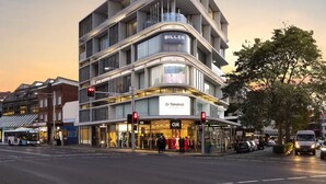 A multi-story building with a modern architectural design, featuring balconies and large windows. - Urban Rest Double Bay Apartments (Double Bay)