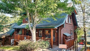 A log cabin with a porch, a covered deck, and a small garden area. - Free Dollywood Tix/Pool/15Min2Dollywood/Pool table (PIgeon Forge)