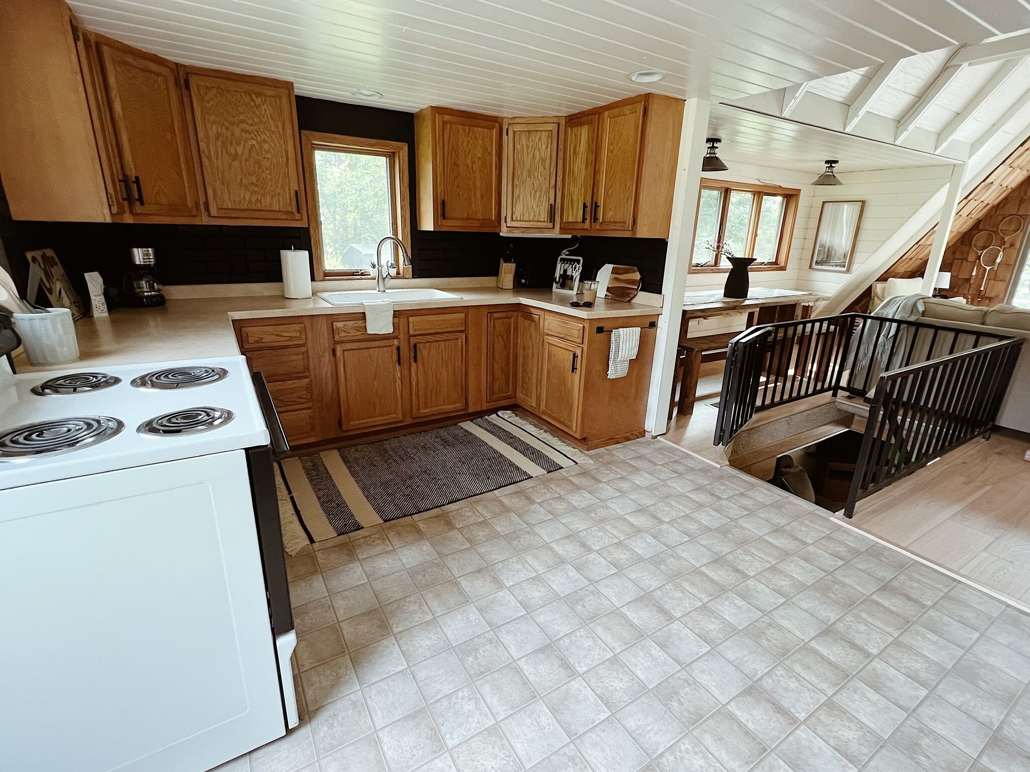 A kitchen with wooden cabinets, a white stove, and a black countertop.