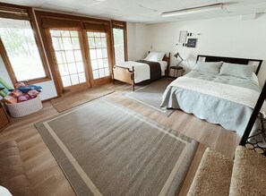 Ein Schlafzimmer mit einem Bett, Nachttischen, einem Teppich und einem Fenster mit Jalousien.