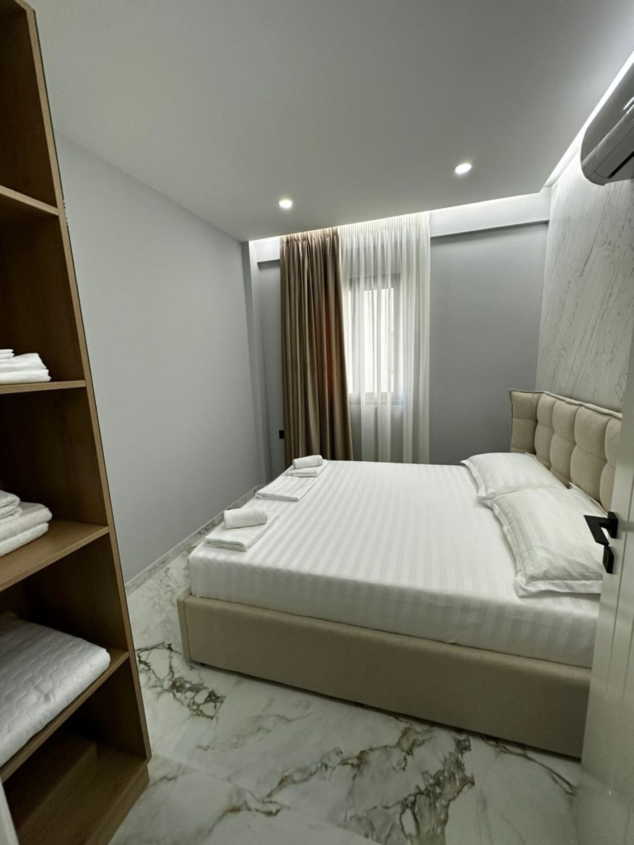 Une chambre à coucher avec un lit, une armoire et un sol en marbre.