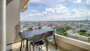 A balcony with a table and chairs, overlooking a cityscape. - Dreamy Landstraße 1BR w/ Pool, Playground & Gym, nr Shops, by Blueground (Vienna)