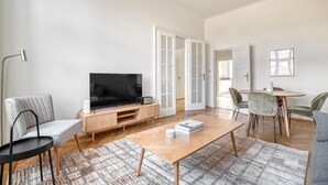 A modern living room with a flat-screen TV, wooden coffee table, and comfortable seating. - Trendy Wieden 2BR w/ Balcony & Elevator, nr Shopping, by Blueground (Vienna)