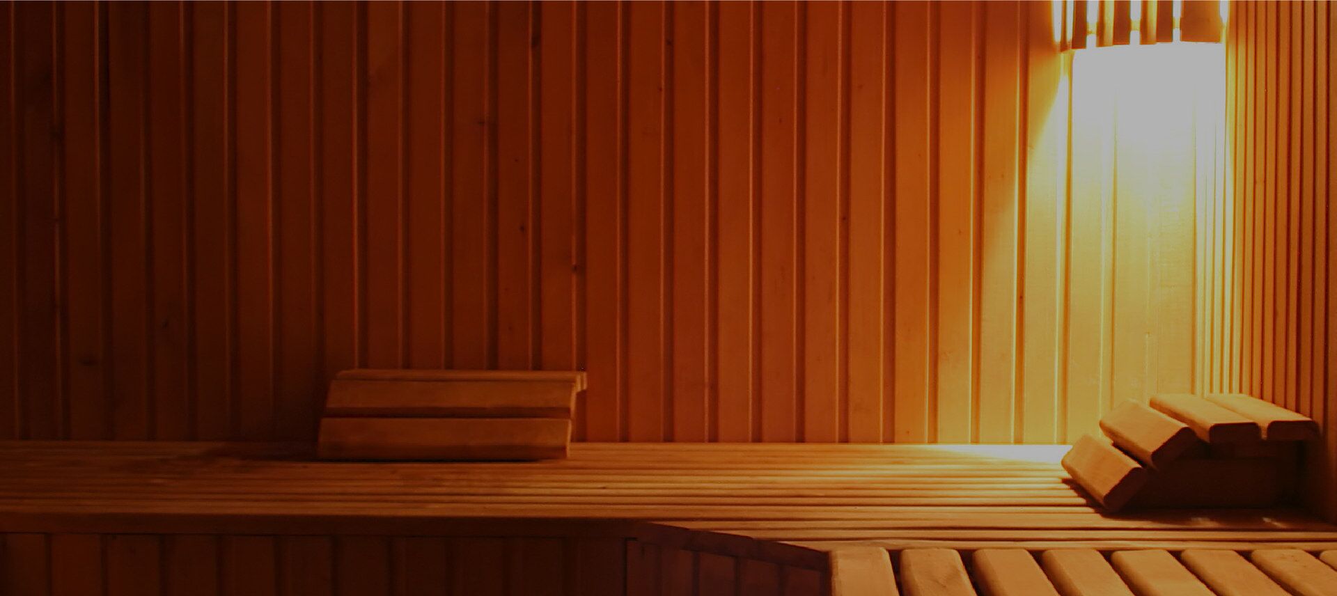 Un sauna en bois, doté de bancs et d’un banc au sol.