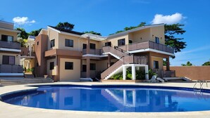 A modern multi-story hotel with a swimming pool, balconies, and a clear blue sky. - THE AQUEDUCTS OF NEGRIL
"Seaview Paradise" (Negril)
