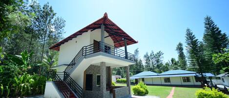 A two-story building with a balcony, a staircase, and a covered outdoor area.